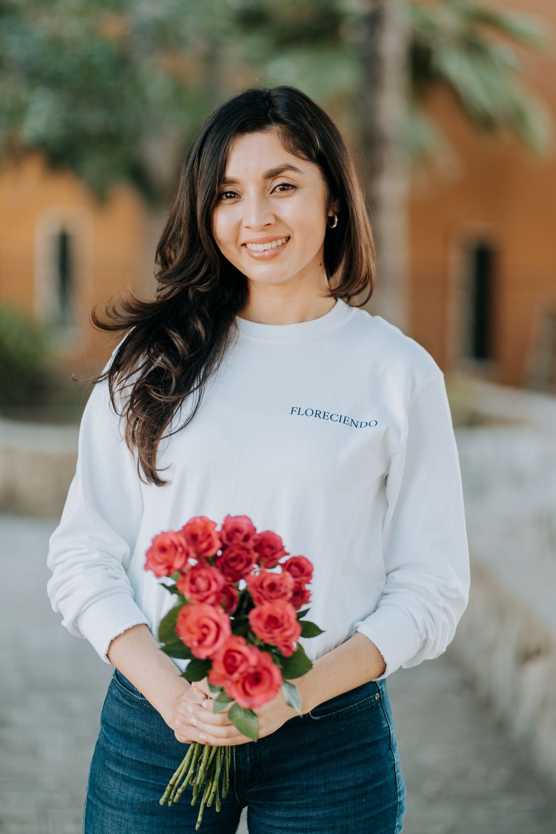 Lizette Flores sonriendo con un ramo de rosas
